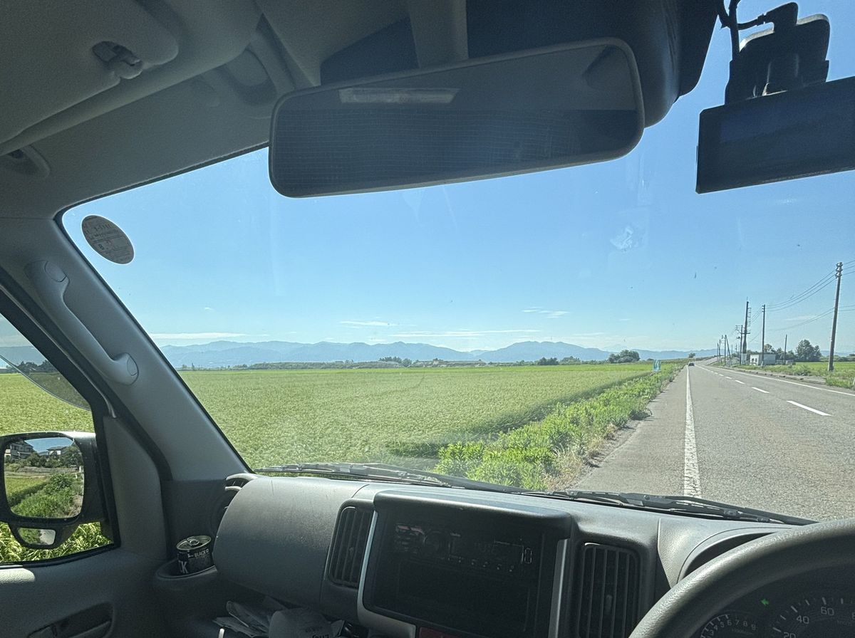 運転席から見た、田園の中を走る道路