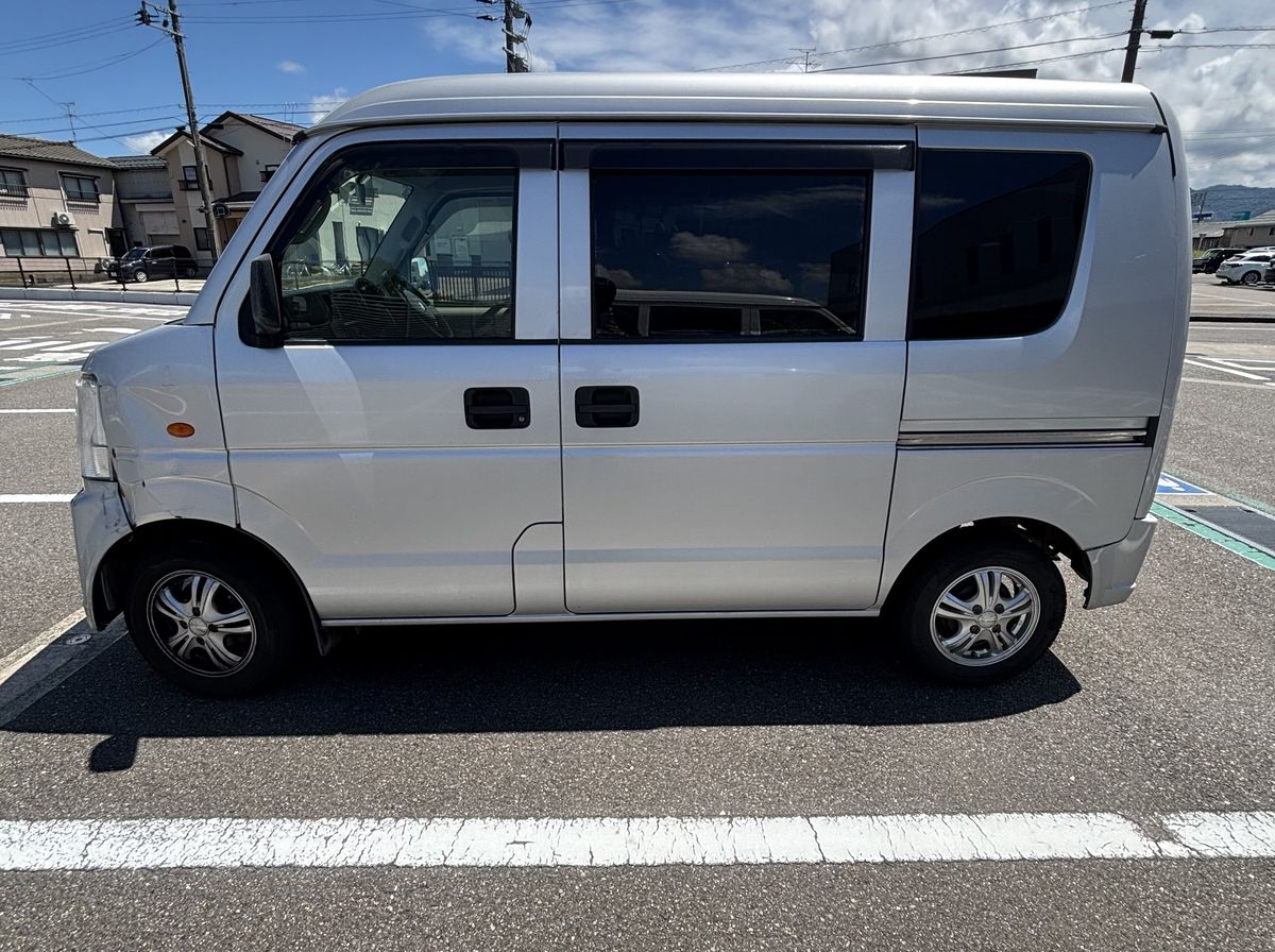 駐車場に停めた銀色の軽バン
